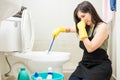 Woman with rubber glove is cleaning toilet bowl using brush. Royalty Free Stock Photo