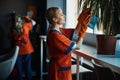 Woman in the rubber gloves cleaning an indoor plant