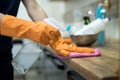 Woman in rubber gloves and cleaning the kitchen counter with sponge Royalty Free Stock Photo