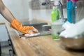 Woman in rubber gloves and cleaning the kitchen counter with sponge Royalty Free Stock Photo