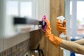 Woman in rubber gloves and cleaning the kitchen counter with sponge Royalty Free Stock Photo