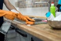Woman in rubber gloves and cleaning the kitchen counter with sponge Royalty Free Stock Photo