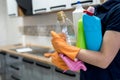 Woman in rubber gloves holding plastic bottles of washing liquid on the kitchen Royalty Free Stock Photo
