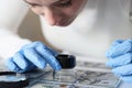 Woman in rubber gloves looking at dollar bills through magnifying glass Royalty Free Stock Photo
