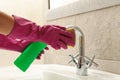 Woman in rubber pink glove cleaning sink