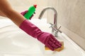 Woman in rubber pink glove cleaning sink