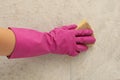 Woman in rubber pink glove cleans tiles