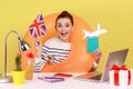 Woman with rubber ring holding passport and british flag, being happy to travel to United Kingdom. Royalty Free Stock Photo