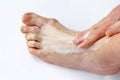 A woman rubbing her foot with a pain ointment