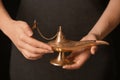 Woman rubbing magical Aladdin lamp, closeup