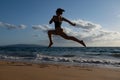 Woman run on the beach. Active sporty girl running along ocean surf by water pool to keep fit and health. Woman fitness Royalty Free Stock Photo