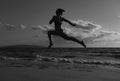 Woman run on the beach. Active sporty girl running along ocean surf by water pool to keep fit and health. Woman fitness Royalty Free Stock Photo