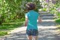 Woman runner jogging in spring park with lilac blossom, morning run outdoors, fitness and running Royalty Free Stock Photo