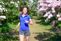 Woman runner jogging in spring park with lilac blossom, morning run outdoors, fitness and running Royalty Free Stock Photo