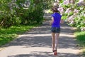 Woman runner jogging in spring park with lilac blossom, morning run outdoors, fitness and running Royalty Free Stock Photo