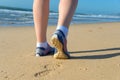 Woman runner legs in shoes on beach Royalty Free Stock Photo