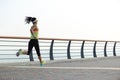 Woman runner running on seaside road