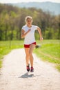 Woman runner runs - workout in spring