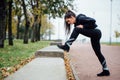 Woman runner stretching legs before run. Royalty Free Stock Photo