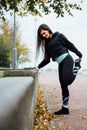 Woman runner stretching legs before run. Royalty Free Stock Photo