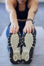 Woman runner stretching, sports shoes and athlete touching toes on a yoga mat on floor for leg fitness warm up exercise Royalty Free Stock Photo