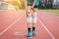 Woman runner suffering from pain in legs be injured,Hand touching her knee after jogging on track running Royalty Free Stock Photo