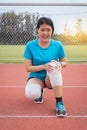 Woman runner suffering from pain in legs be injured,Hands touching her knee after jogging and workout outdoor on track running Royalty Free Stock Photo