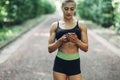 Woman Runner in the Summer Morning Park Listening to Music on Smartphone Using Bluetooth Earphones. Female Fitness Girl Jogging on Royalty Free Stock Photo