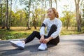 A woman runner tying shoelaces and getting ready for run in city park Royalty Free Stock Photo