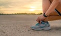 Woman runner tying sport shoes and getting ready for run at the park in the morning. Asian Female cardio exercise for healthy life Royalty Free Stock Photo