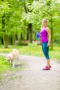 Woman runner walking with dog in summer park Royalty Free Stock Photo
