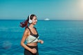 Woman running along ocean. Fresh air and virgin nature view. Active sport time fitness and healthy lifestyle concept