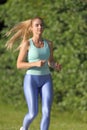 Woman running along the road in the forest Royalty Free Stock Photo