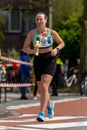 Woman running along the road during a marathon in Leiden.