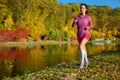 Woman running in autumn park, beautiful girl runner jogging