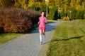 Woman running in autumn park, beautiful girl runner jogging outdoors Royalty Free Stock Photo