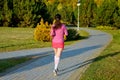 Woman running in autumn park, beautiful girl runner jogging outdoors Royalty Free Stock Photo
