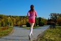 Woman running in autumn park, beautiful girl runner jogging outdoors Royalty Free Stock Photo