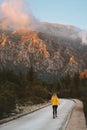 Woman running away on the road to sunset mountains travel lifestyle vacations weekend getaway outdoor Royalty Free Stock Photo