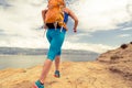 Woman running with backpack on rocky trail at seaside Royalty Free Stock Photo