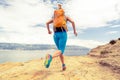 Woman running with backpack on rocky trail at seaside Royalty Free Stock Photo