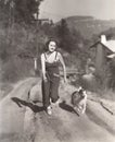Woman running on dirt road with her dog Royalty Free Stock Photo