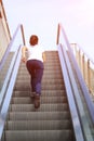 woman running on escalator stairs Royalty Free Stock Photo