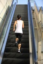 Woman running on escalator stairs Royalty Free Stock Photo