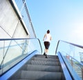 Woman running on escalator stairs Royalty Free Stock Photo