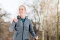 Woman running down a path on winter day in park Royalty Free Stock Photo