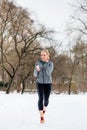 Woman running down a path on winter day in park Royalty Free Stock Photo