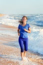 Woman running by the ocean or sea beach Royalty Free Stock Photo