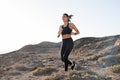 Woman running over rocks and low grass Royalty Free Stock Photo