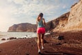 Woman running on Red beach on Santorini island. Female runner jogging during outdoor workout enjoying view Royalty Free Stock Photo